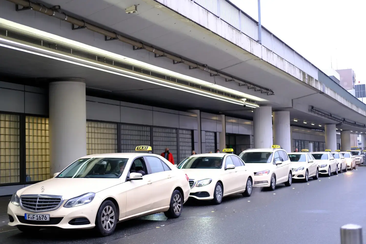 Taxistand am Frankfurter Flughafen in Deutschland, weiße Autos mit gelben Schildern am Eingang warten auf Fluggäste, die in Frankfurt angekommen sind, das Konzept des Stadtverkehrs, Annehmlichkeiten für Menschen